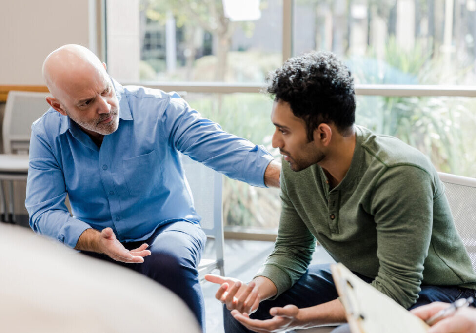 Mature man helps younger man verbalize problems in therapy