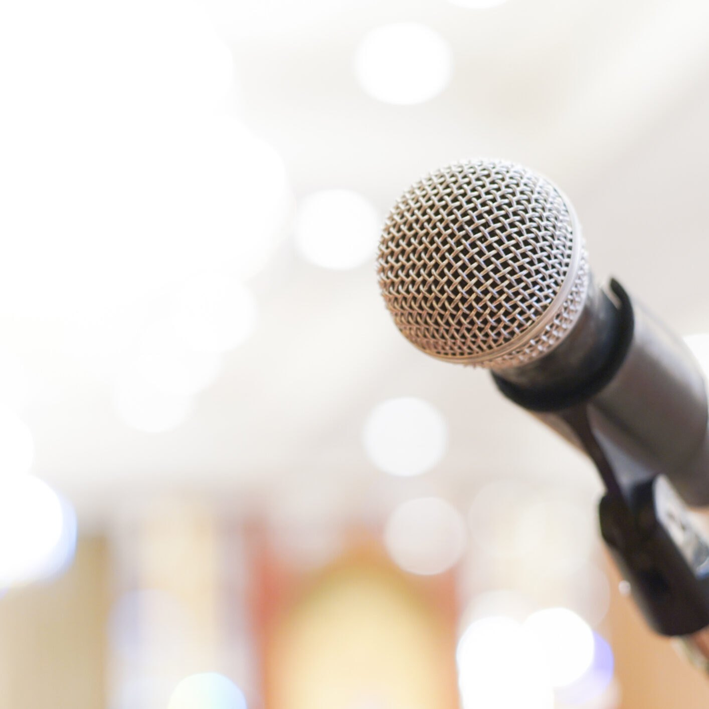 Microphone over the abstract blurred conference hall room