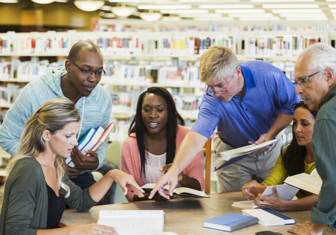 Adult students studying  together in library